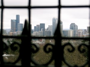 Seattle skyline in focus with black wrought-iron fence in front and out of focus